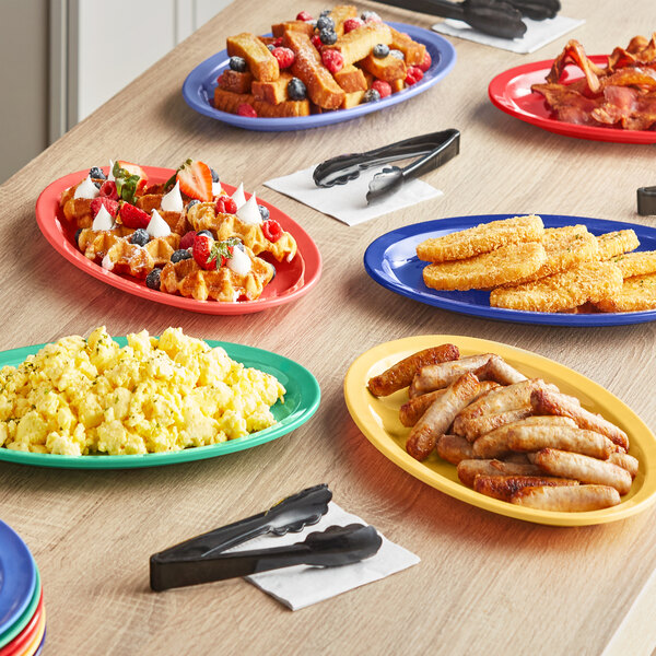 An oval melamine platter with waffles and fruit on it.