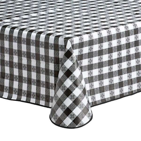 A close-up of a Choice black textured gingham vinyl table cover with umbrella opening on a table.