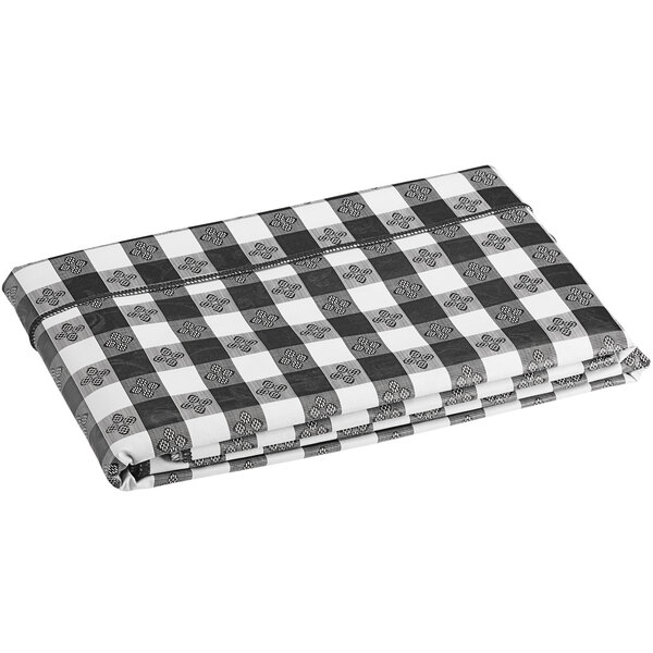 A folded black and white plaid Choice vinyl table cover.