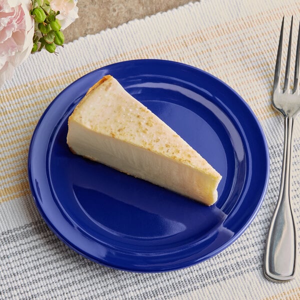 A slice of cheesecake on a blue plate next to a fork.