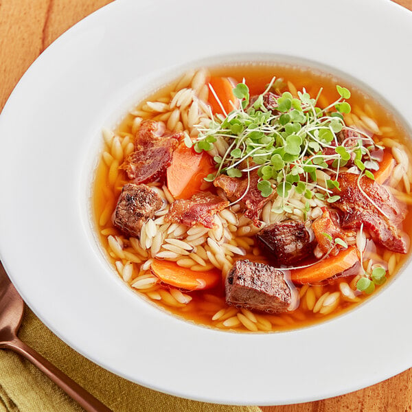 A bowl of College Inn Organic Beef Broth with vegetables and meat.