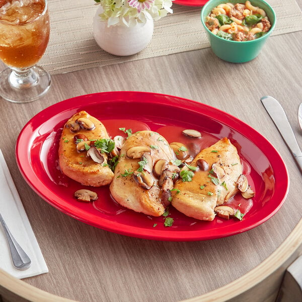 An Acopa red melamine oval platter with food on it.