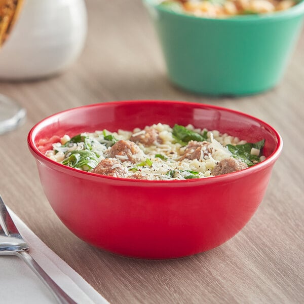 A red Acopa Foundations melamine nappie bowl filled with food on a table.