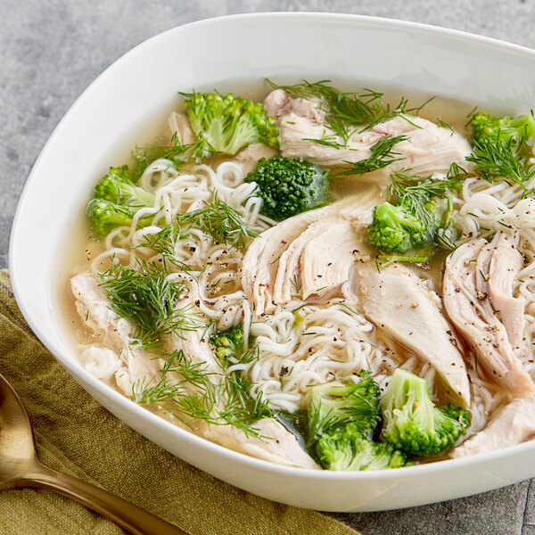 A bowl of College Inn organic chicken broth with broccoli, noodles, and chicken.