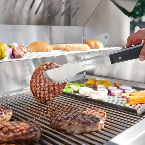 A person using a Crown Verity built-in grill to cut meat on a counter.
