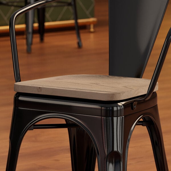 A Lancaster Table & Seating black metal chair with a gray wood seat.