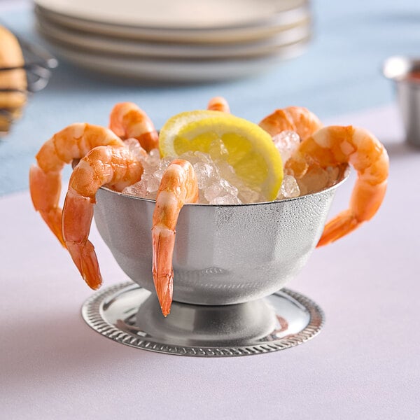 A Vollrath Seafood Supreme stainless steel bowl filled with shrimp and lemon wedges on ice.