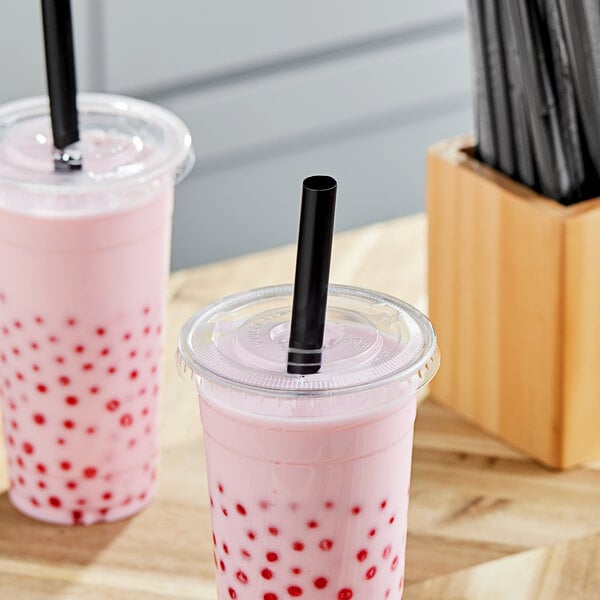 Two plastic cups with pink boba drinks and black straws.