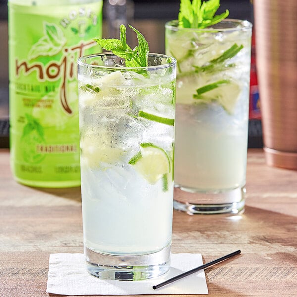 Two glasses of Rose's mojitos with ice and mint leaves.