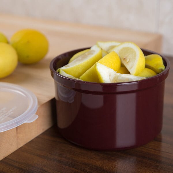 A Carlisle brown plastic crock filled with lemons.