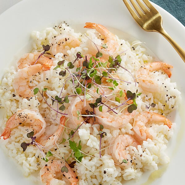 A plate of Campanini Vialone Nano rice with shrimp and a fork.