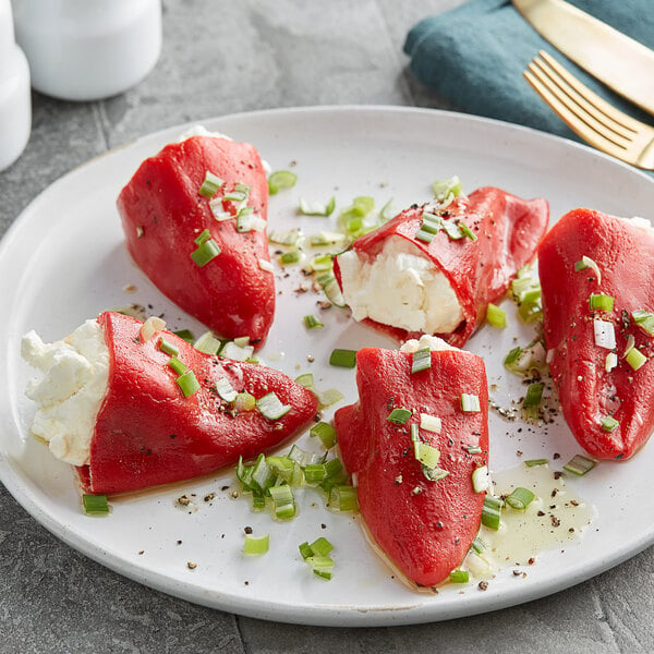 A plate of Del Destino roasted Piquillo peppers stuffed with white cream cheese and green onions.