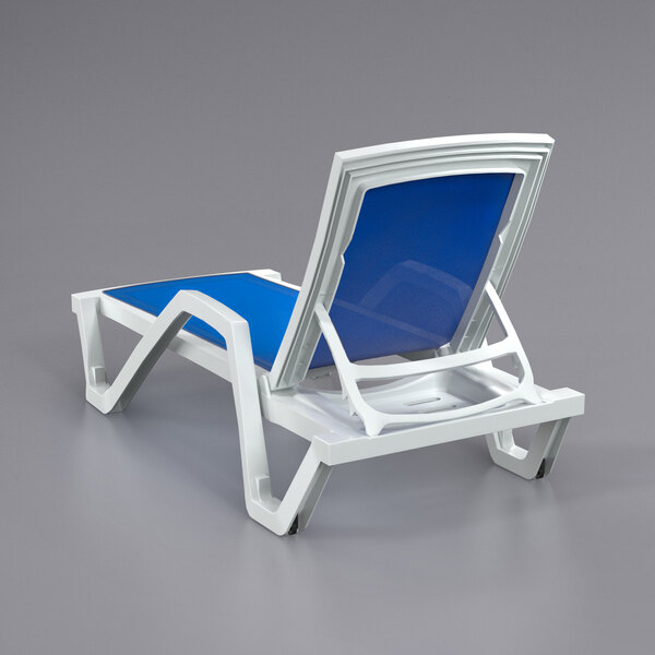 A white Lancaster Table & Seating chaise lounge chair with a blue sling seat.