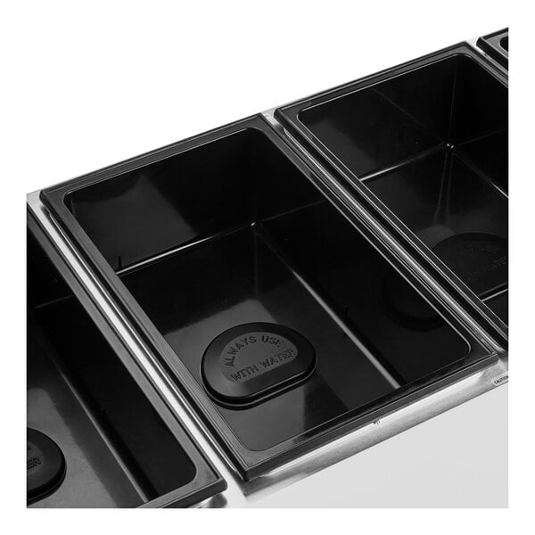 A Vollrath ServeWell electric hot food table with three black rectangular pans inside.