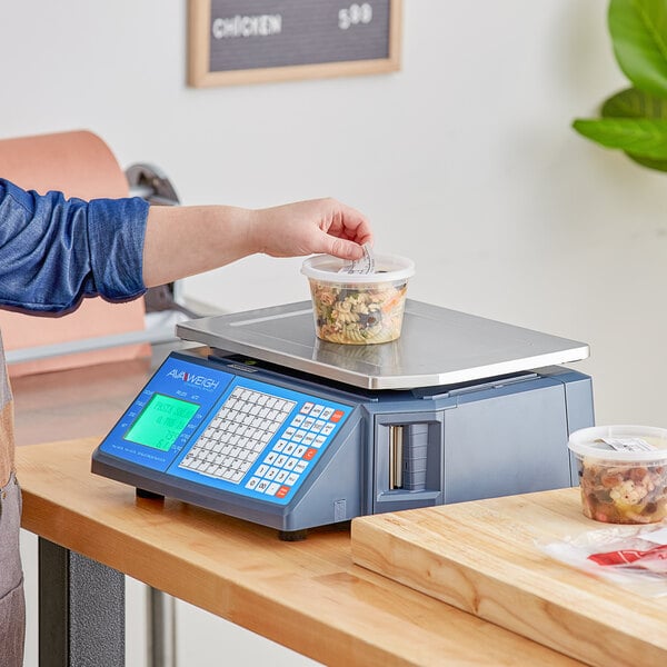 A woman using an AvaWeigh thermal label printing scale to weigh pasta in a plastic container.