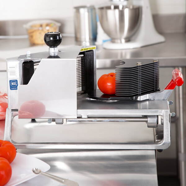 A Vollrath Redco InstaSlice cutter with scalloped blades slicing tomatoes.