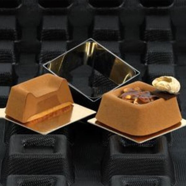 Sasa Demarle Flexipan Square Savarin Tartlets on a tray with food.