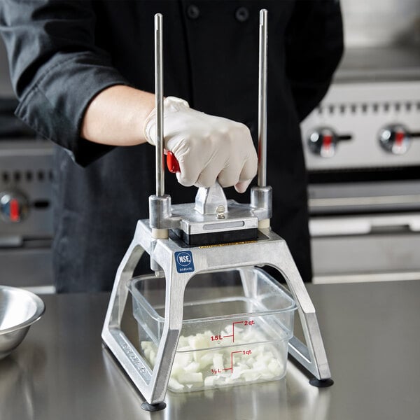 A tabletop-mounted fruit and vegetable dicer with a hand-operated lever and a clear container for collecting diced produce.