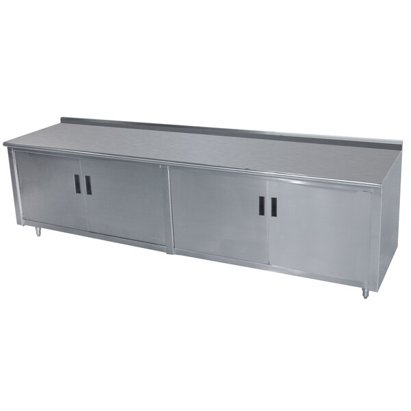 A stainless steel Advance Tabco enclosed base work table with a fixed midshelf.