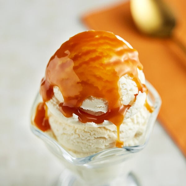 A scoop of ice cream with Creamery Ave. Caramel Dessert sauce on top.