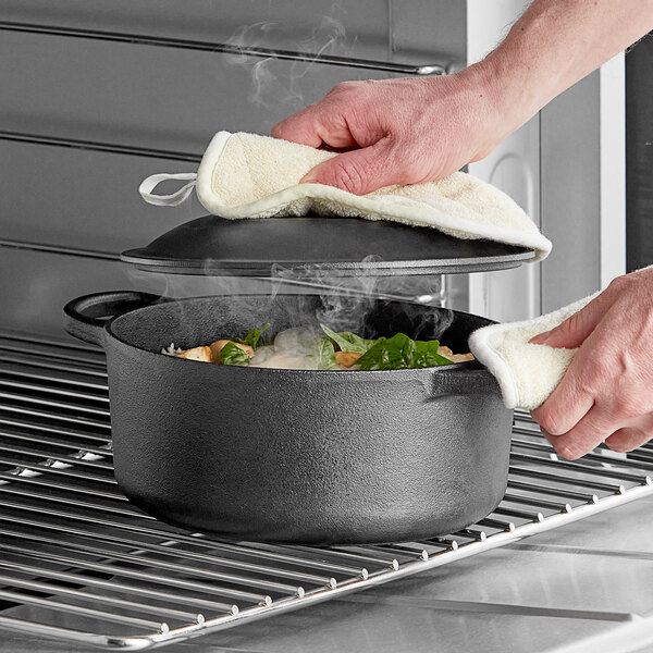 A person using Valor cast iron dutch oven to cook food.
