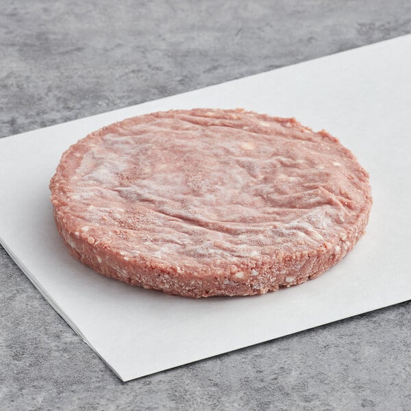 An Impossible Foods vegan plant-based burger patty on a white paper.