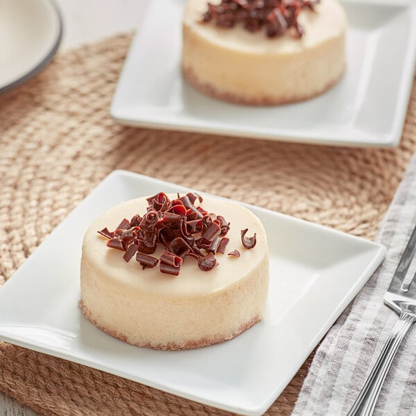 Two David's Cookies Mini New York Cheesecakes on white plates with chocolate and red sprinkles.