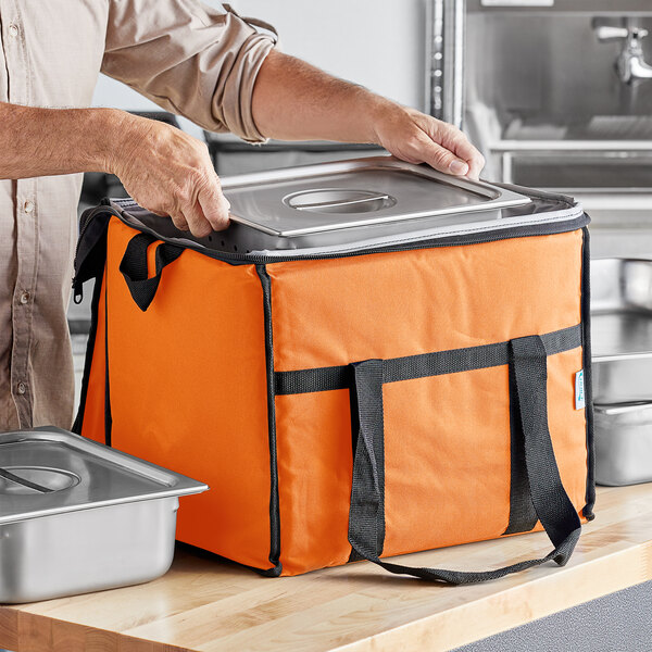 A man holding an orange Choice insulated cooler bag.