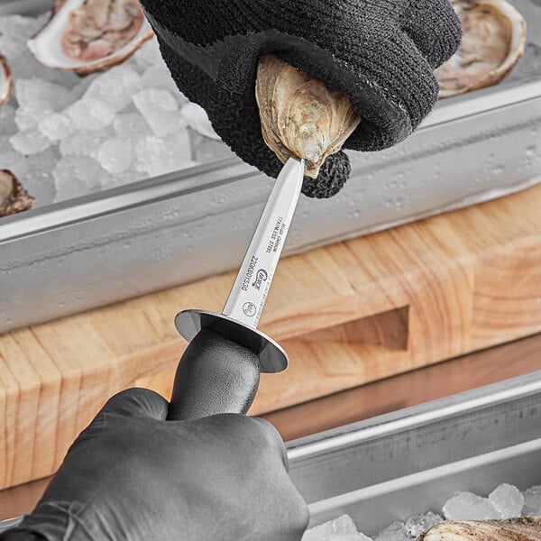 a hand in a black glove holding a metal object