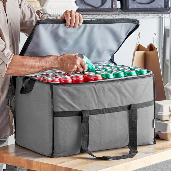 A man holding a Choice large insulated cooler bag full of cans.