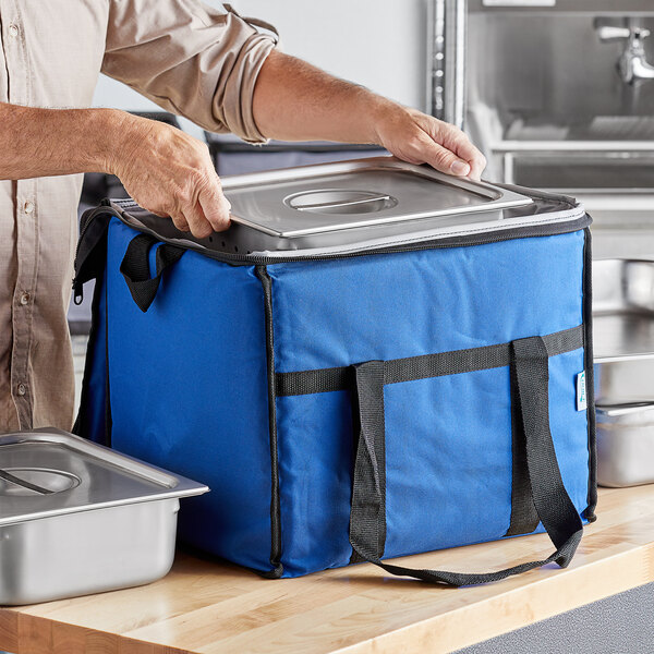 A person holding a blue Choice insulated cooler bag.