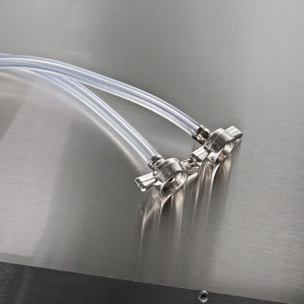 A stainless steel water hose with two plastic tubes connected to a pipe.