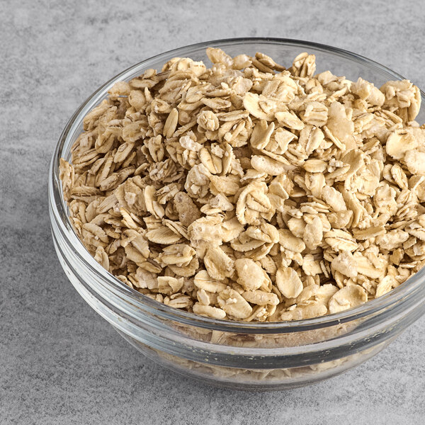 A clear glass bowl filled with classic granola.