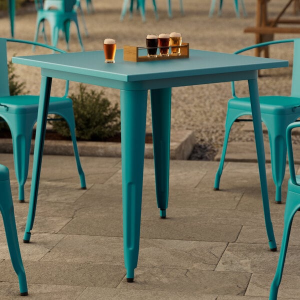 A Lancaster Table & Seating outdoor table with a tray of beer on it.