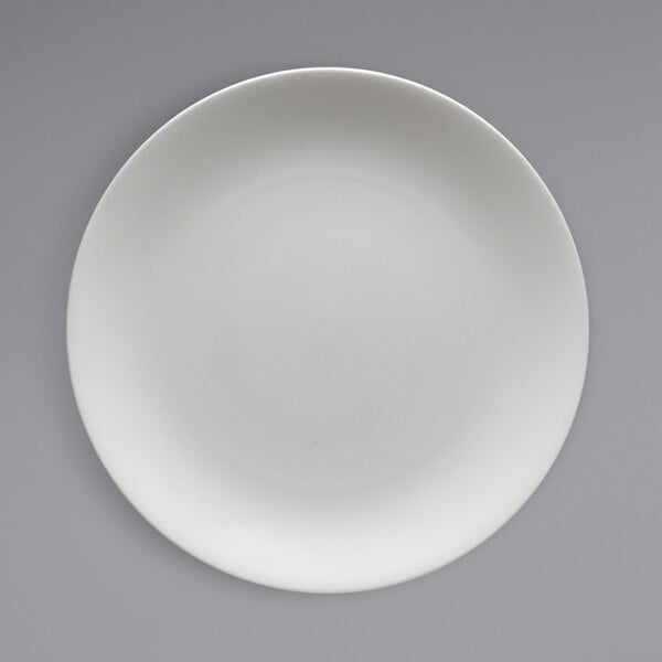 A close up of a Fortessa Caldera bright white coupe china plate.