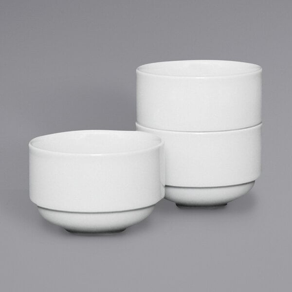 A stack of Fortessa Ilona bright white China bouillon cups.