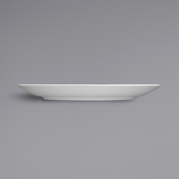 A Fortessa Caldera bright white china plate on a gray background.