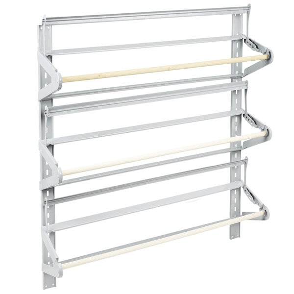 A white metal wall rack with white rods for three paper rolls.