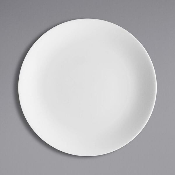 A Fortessa Caldera bright white china plate on a gray surface.