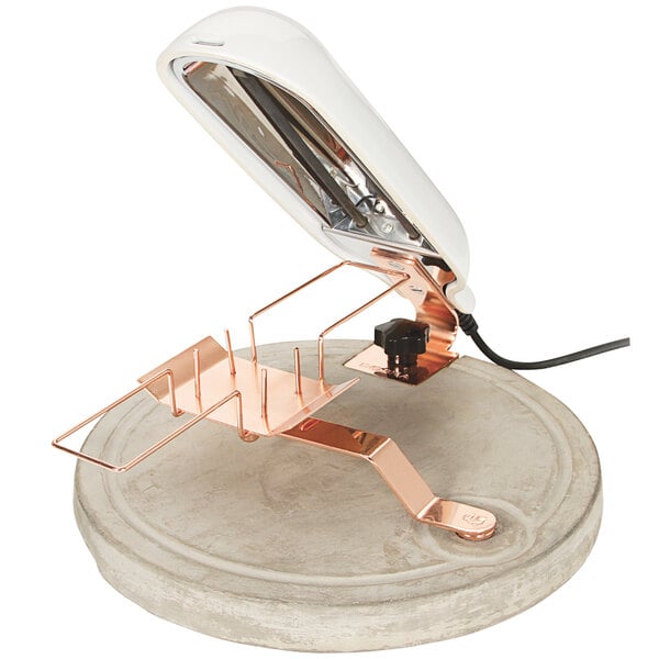A white lamp with a copper and concrete stand.