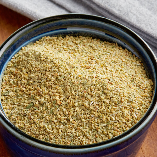 A bowl of food seasoned with Goya Sazonador Total Seasoning on a wooden table.