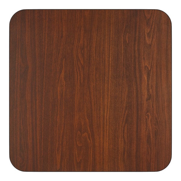 A square, reversible laminated table top with a walnut finish.