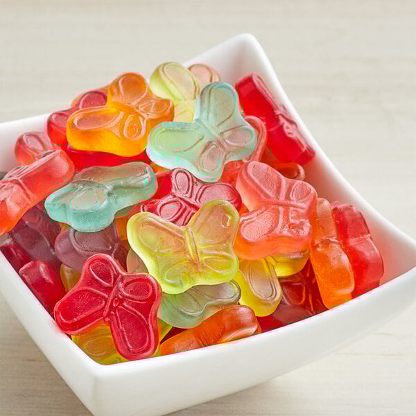 A bowl filled with Albanese Mini Gummi Butterflies on a white background.