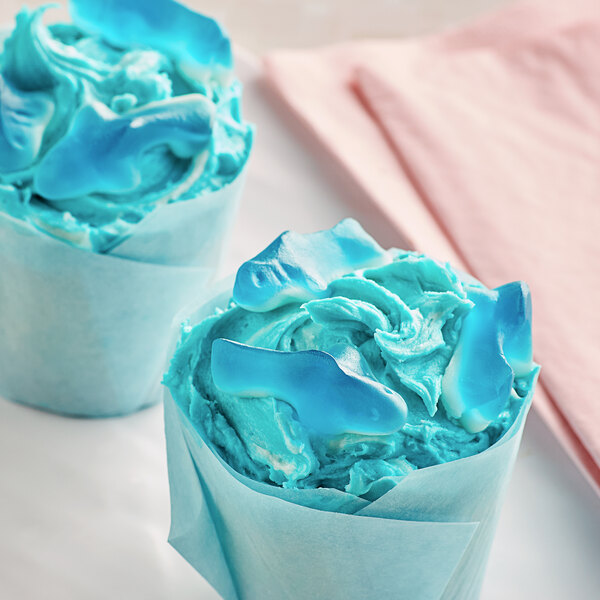 A white paper with two blue Vidal Gummy Shark cupcakes.