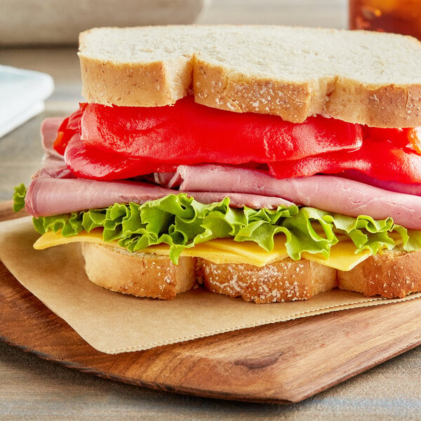 Sliced sandwich with meat, cheese, and Goya Fancy Red Pimientos.