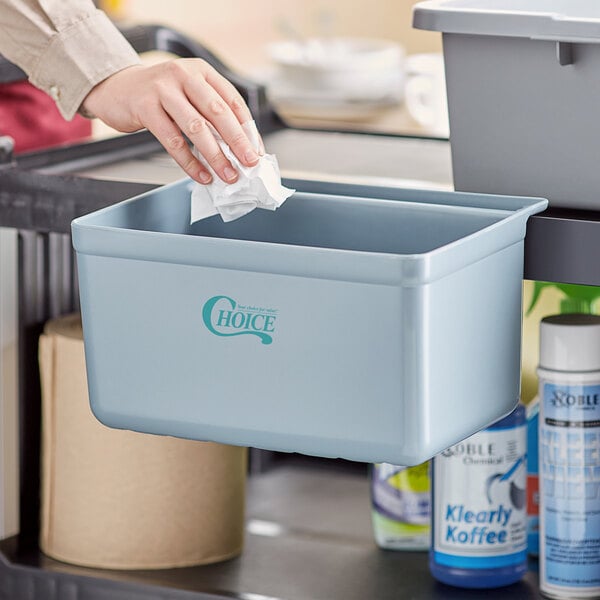 A woman's hand putting a tissue into a gray polyethylene container.