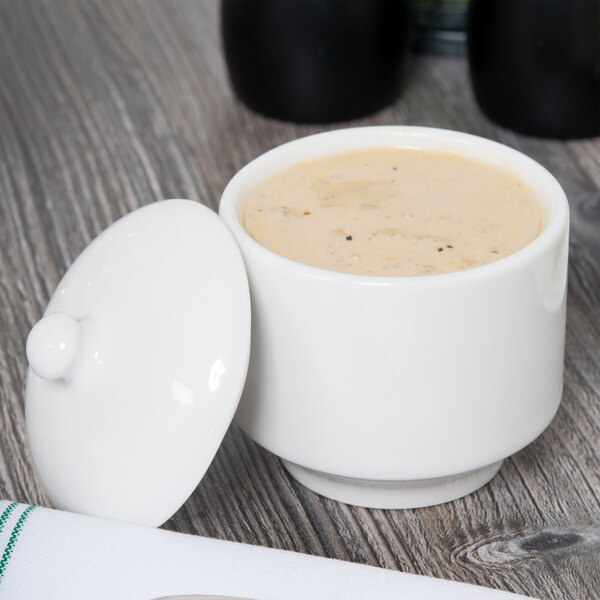 A white Homer Laughlin bouillon bowl with a spoon on top.