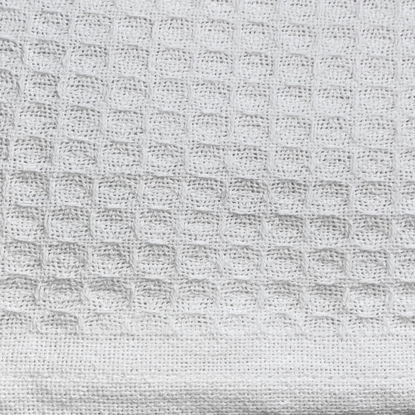 A close up of a white knitted fabric with a honeycomb pattern.