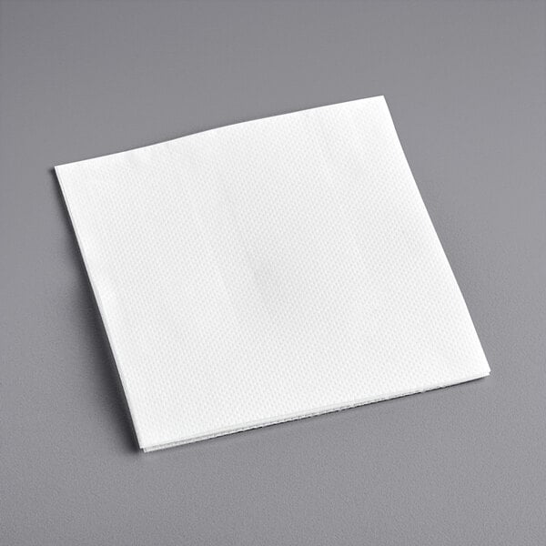A Hoffmaster white linen-feel beverage napkin on a gray surface.