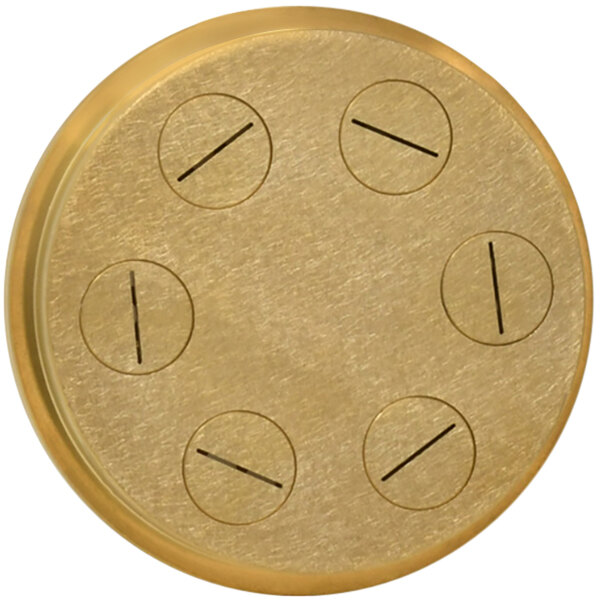A circular brass object with a black line and five holes.